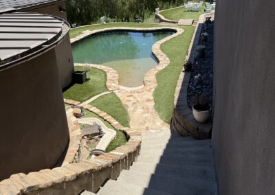 View leading down stairs and towards an inground pool